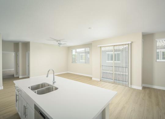 A kitchen with a white countertop and a stainless steel sink.