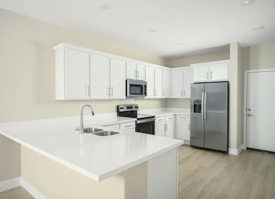 A kitchen with white cabinets and appliances.
