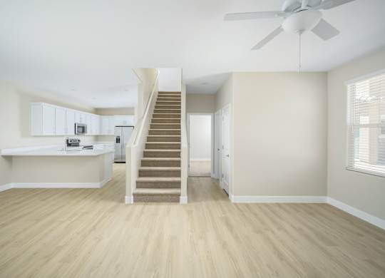 A room with a staircase and a fan.