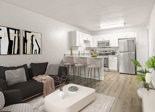 Pet-friendly open living room with kitchen in the background and large white coffee table at Addison Lane Apartment Homes in Gainesville, Florida