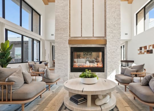 a living room with couches and a coffee table in front of a fireplace