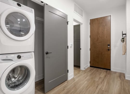 a white washer and dryer in a room with a door