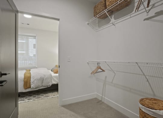 the closet in a bedroom with a bed and a mirror