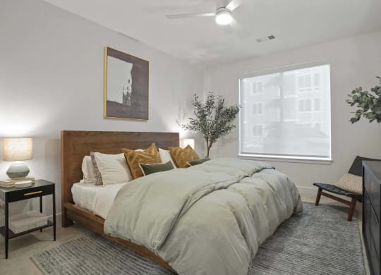 Two-Bedroom Apartments in Castle Rock, CO - Alana - Bedroom with Plush Carpet Flooring, Ceiling Fan, and Large Window
