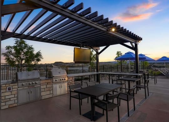 a patio with a grill and tables and a tv