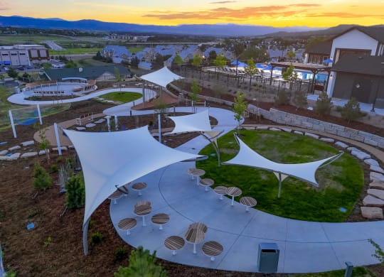 an aerial view of a park with shade structures
