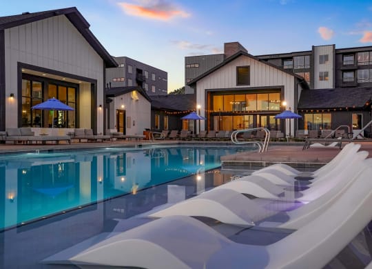 1-Bedroom Apartments in Castle Rock, CO - Alana - Resort-Style Pool with Lounge Chairs, Umbrellas, and Daybeds