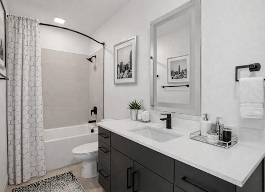 A bathroom with a white sink, a white toilet, and a white bathtub with a shower curtain.