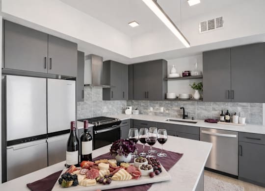 A modern kitchen with a stainless steel refrigerator and a white countertop.