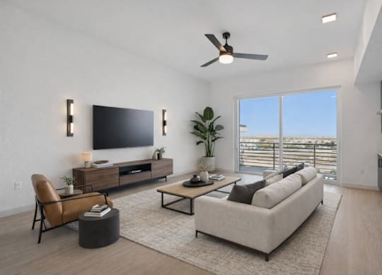 A modern living room with a flat screen TV, a sofa, a chair, and a potted plant.