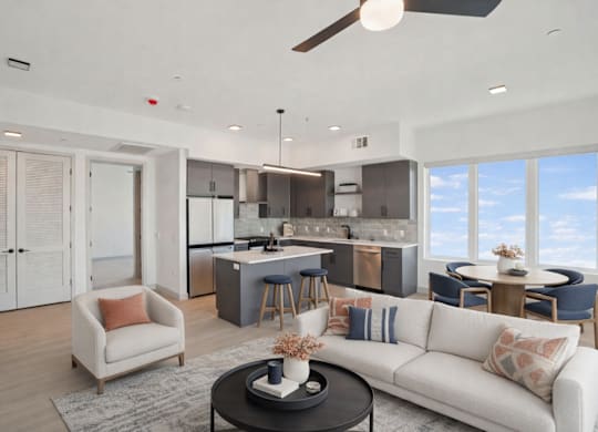 A modern living room with a kitchen in the background.