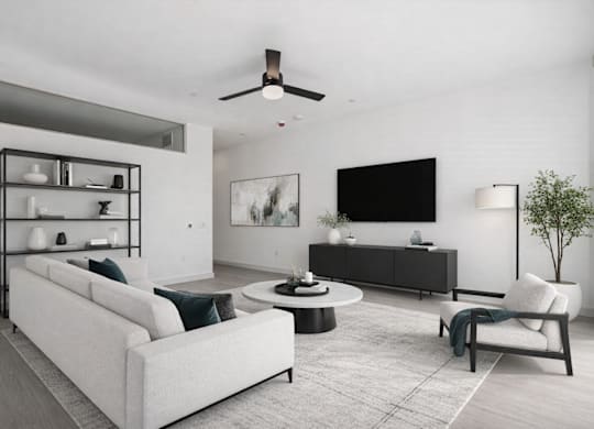 A modern living room with a white sofa, a black TV, and a white chair.