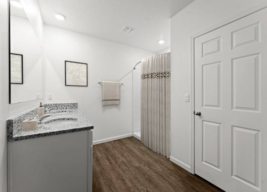A bathroom with a sink, mirror, and towel rack.