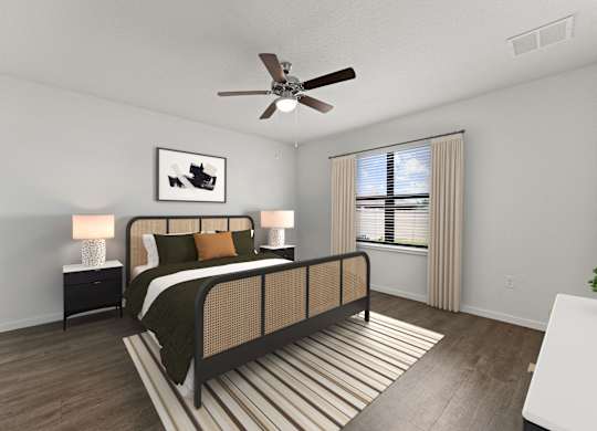 A bedroom with a bed, nightstand, and a ceiling fan.