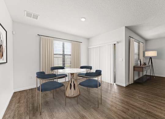 A dining room with a round table and chairs.