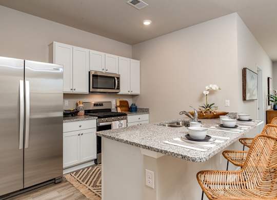 a kitchen with white cabinets and stainless steel appliances