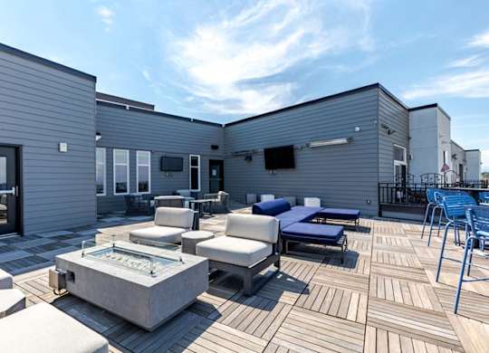 a patio with couches and chairs and a fire pit