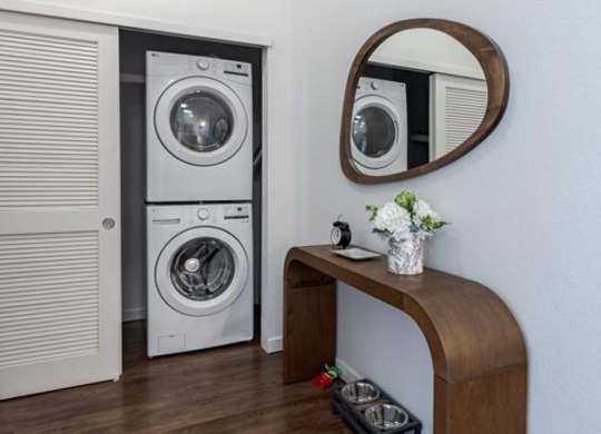 a laundry room with a washing machine and a mirror