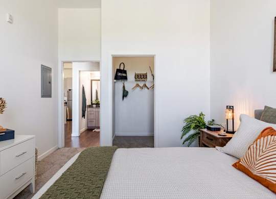 a white bedroom with a bed and a hallway