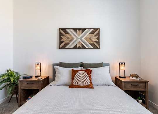 a bedroom with a bed and a painting on the wall