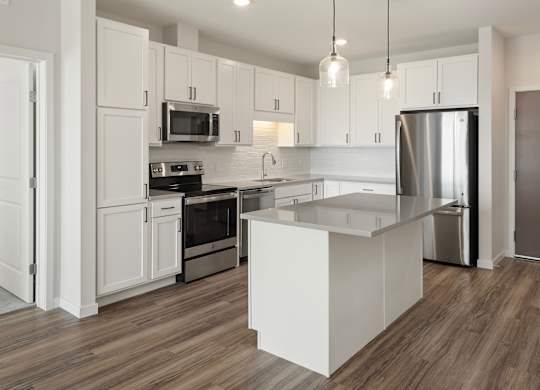 A modern kitchen with white cabinets and stainless steel appliances.