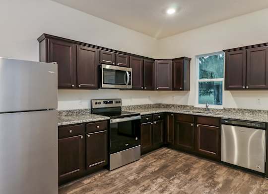 A kitchen with brown cabinets and stainless steel appliances.