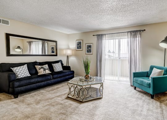 “Open and spacious living room with two large sliding window doors at Aurora Meadows apartments in Aurora, Colorado