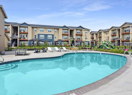 a swimming pool with an apartment building in the background