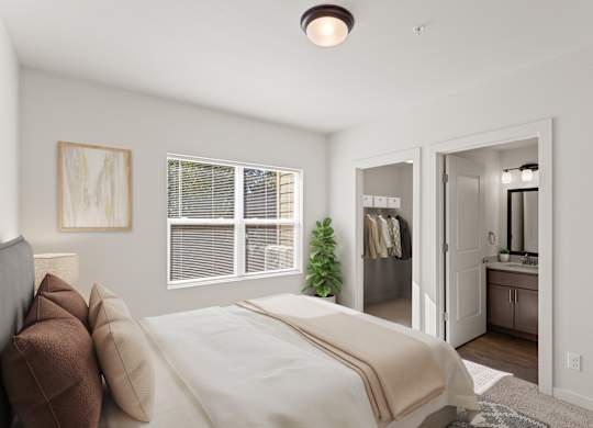 A bedroom with a bed, a mirror, and a plant.