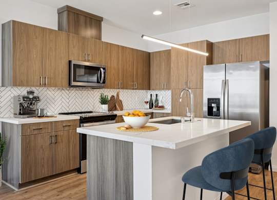 A modern kitchen with a white countertop and wooden cabinets.