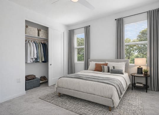 A bedroom with a large bed and a window with curtains.