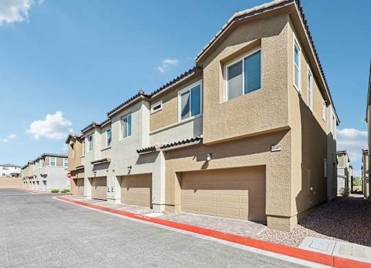 A row of houses with garages and driveways.