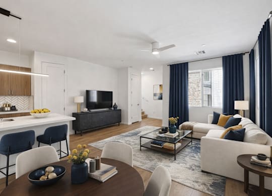 A modern living room with a white sofa, a wooden coffee table, and a dark-colored television.