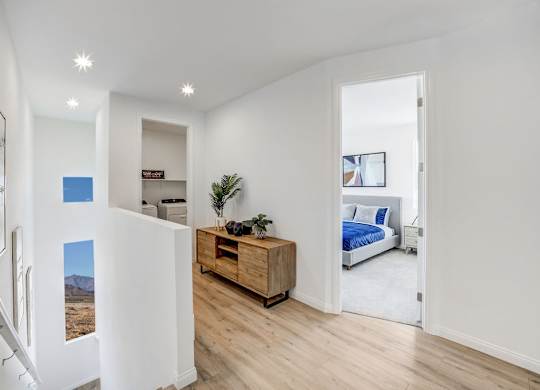 a living room with a bed and a wooden floor