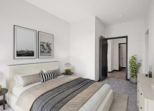 A bedroom with a large bed, a mirror, and two framed pictures on the wall.