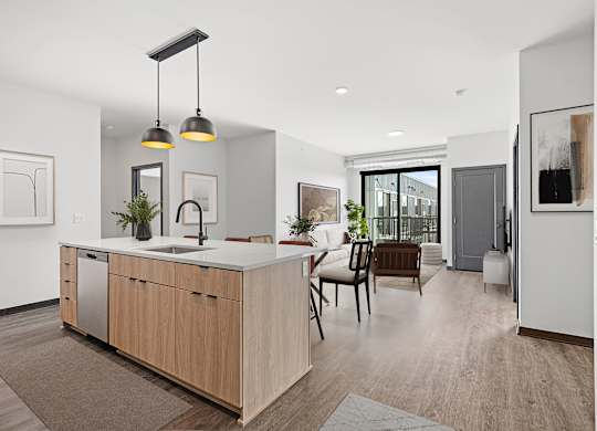 A modern kitchen with a wooden island and pendant lights.