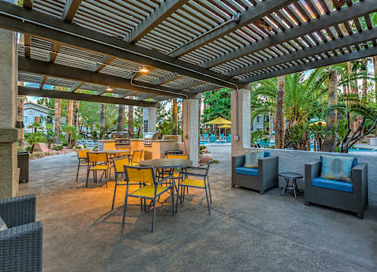 A patio with a table and chairs under a roof.