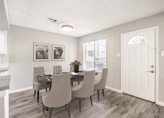 A dining room with a table set for six.