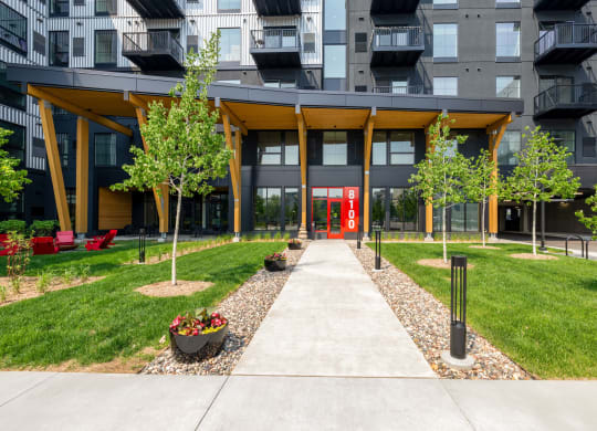 pathway leading to an apartment building with grass and trees