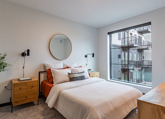 a bedroom with a bed and a large window