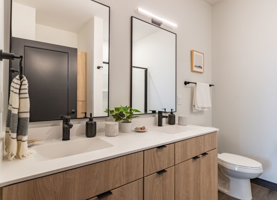 a bathroom with two mirrors and a sink and a toilet