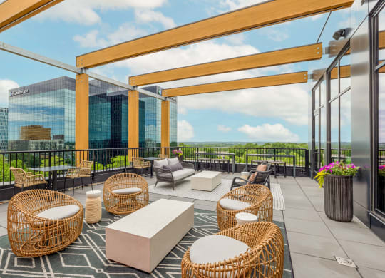 a rooftop patio with chairs and tables and a view of the city