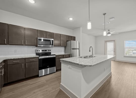 an open kitchen with a large island and stainless steel appliances