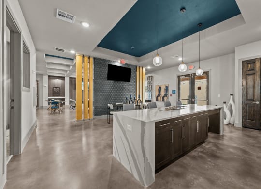 a kitchen with a large island and a living room with a table and chairs
