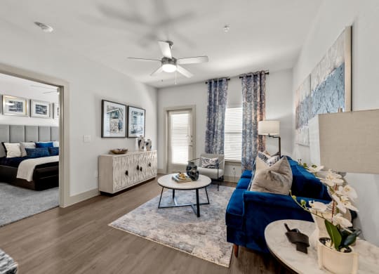 a living room with a blue couch and a ceiling fan