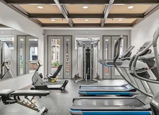 A gym with treadmills, exercise bikes, and other equipment.