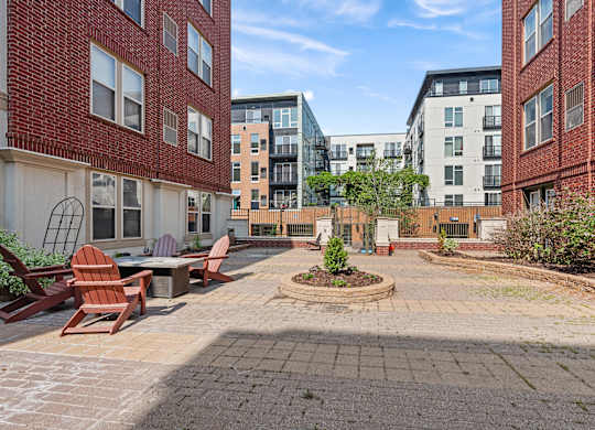 A courtyard with a circular garden and chairs.