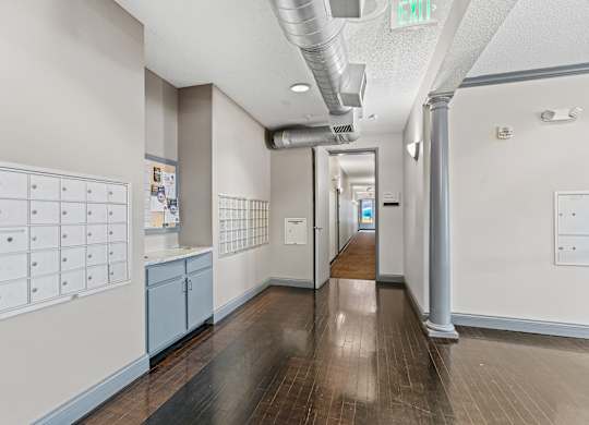 A long hallway with a white wall and a blue cabinet.