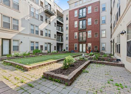 A courtyard with a brick wall and a small garden.