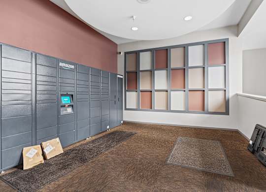 A room with a brown carpet and a wall with Amazon written on it.